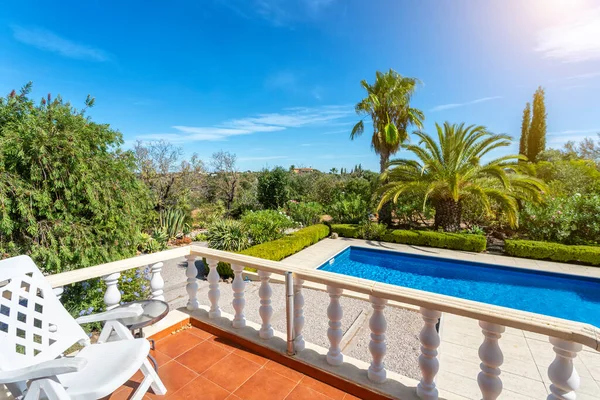 Uitzicht vanaf het terras naar het luxe zwembad met helder water in de tuin. Voor toeristen. — Stockfoto