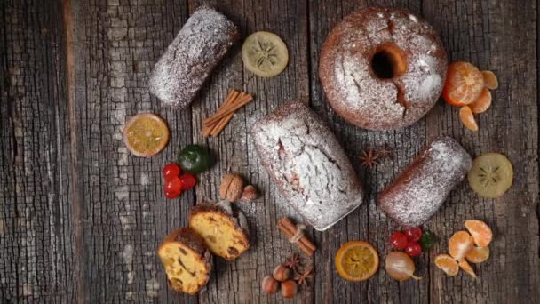 Julen sammansättning av torkade frukter och stollen, med mandarin, på ett trästrukturerat bord, med kryddor. Vid jul. — Stockvideo