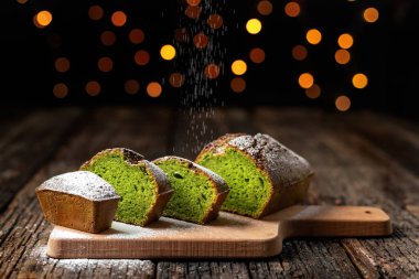 Çalıntı Noel ekmeği spirulina ve şam fıstığından yapılmış, şekersiz, bayram için diyet. Ahşap bir masanın üzerinde, arka planda Bokeh ışıkları.