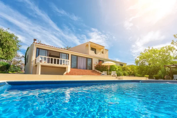 En lyxig pool med klart blått vatten med utsikt över trädgården villa. Uthyres till turister. — Stockfoto