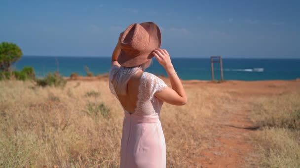 一个戴着帽子的女孩在岸上等着一个年轻人和她去参加一个浪漫的聚会Honeymoon 。情人节. — 图库视频影像