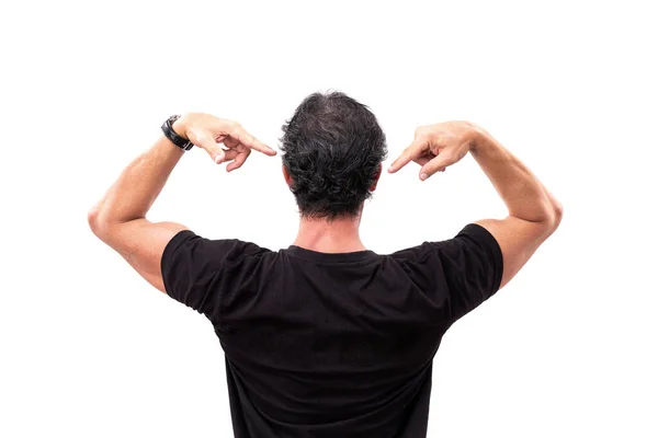 Un hombre con una camiseta negra, la espalda, señala con los dedos a la espalda, para publicidad o marketing de productos. Sobre un fondo blanco aislado. —  Fotos de Stock