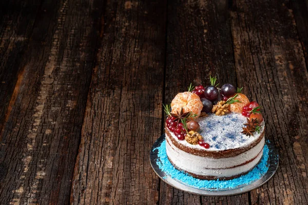 Delicioso bolo de frutas feito de ingredientes deliciosos e creme, em um fundo texturizado de madeira. Close-up. — Fotografia de Stock
