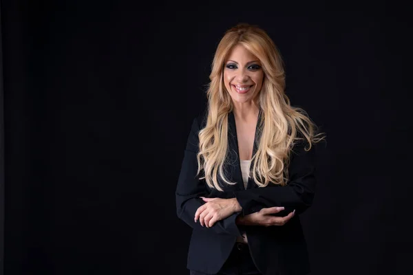 Hermosa modelo europea, mujer de negocios, rubia de mediana edad, posando en el estudio sobre un fondo negro. —  Fotos de Stock