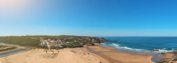 Encantadora vista panorámica de la playa portuguesa del pueblo de Odeceixe con los turistas en verano. Imágenes de stock libres de derechos