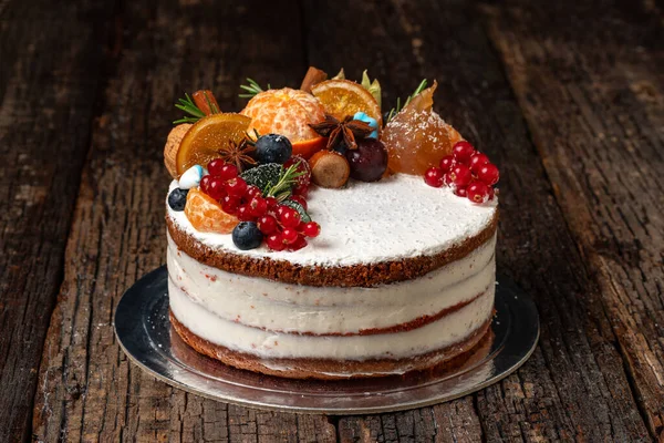 Köstlicher Obstkuchen aus köstlichen Zutaten und Sahne, auf einem hölzernen strukturierten Hintergrund. Nahaufnahme. Stockbild