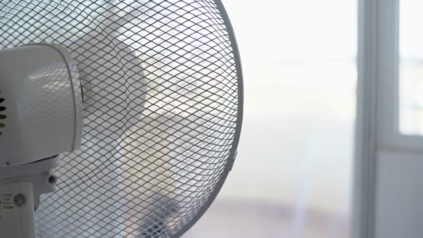 Electric fan for cooling the room in the summer, the heat. Blurred background. Overexposure. High key. — Stock Video