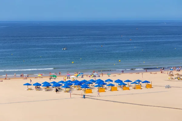 Bonito tiro de playa aérea limpia con un montón de sombrillas principalmente azul y un agua clara y el cielo. —  Fotos de Stock