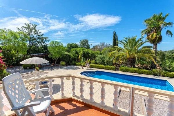 Uitzicht vanaf het terras naar het luxe zwembad met helder water in de tuin. Voor toeristen. — Stockfoto