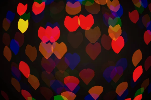 Coeurs flous multicolores, bokeh, lumières sur fond noir, symbole d'amour pour la Saint-Valentin. — Photo