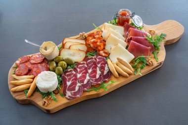 Peynirli ve füme etli çok renkli tapas masası var. Roka ve cevizle süslenmiş..