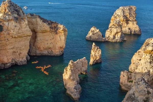 Vista scogliera costiera con kayak nelle acque di Ponta da Piedade, Lagos, Portogallo. — Foto Stock