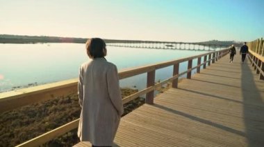 Nehir kıyısında sahil kenarında yürüyen iki kadın ve önünde insanlar var. Sao Lourenco Quinta de Lago, Almancil. Portekiz