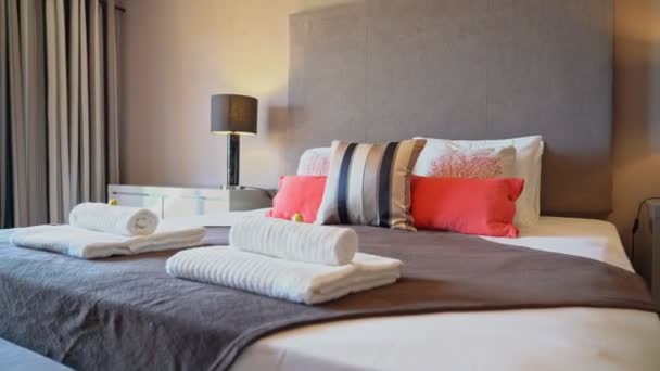 Powiększ poduszki umieszczone na łóżku w naturalnie dobrze oświetlonej i schludnej nowoczesnej sypialni. — Wideo stockowe