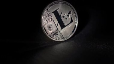 Parlak Litecoin LTC ahşap bir yüzey üzerinde dönen ve ışığı yansıtan. engelleme zinciri