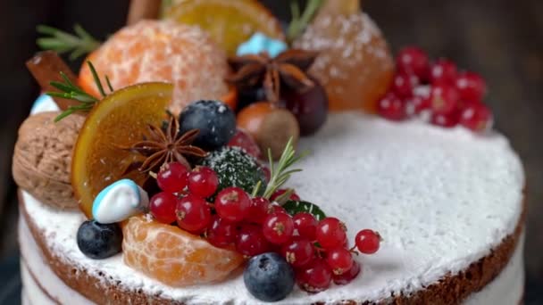 Pastel festivo de Año Nuevo decorado con todo tipo de frutas girando en un soporte giratorio. — Vídeo de stock