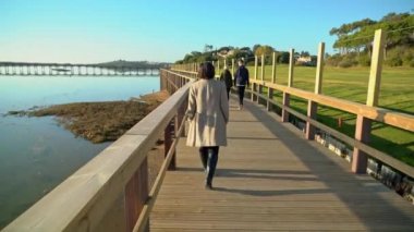 Nehir kıyısında sahil kenarında yürüyen iki kadın ve önünde insanlar var. Sao Lourenco Quinta de Lago, Almancil. Portekiz