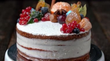 Dönen bir tezgahta dönen her türlü meyveyle süslenmiş Noel pastası..