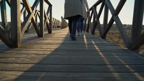 Dos hembras caminando en un paseo marítimo cerca de una orilla del río con gente adelante. Sao Lourenco Quinta de Lago, Almancil. Portugal — Vídeos de Stock