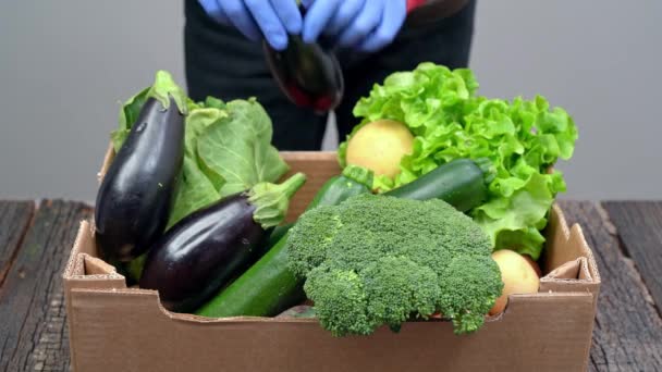 一个男人把新鲜蔬菜放进装有卫生手套的盒子里，捐赠给穷人和穷人。在大流行病期间，交付. — 图库视频影像
