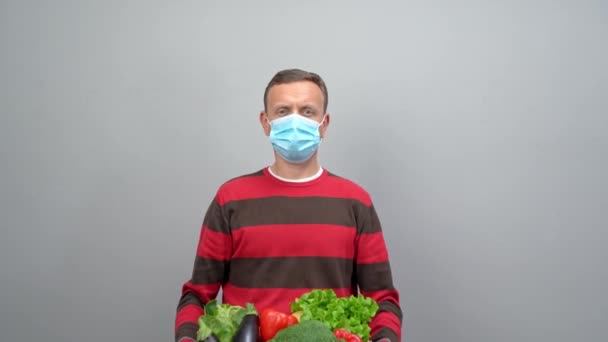 A male volunteer delivers food and vegetables to people in quarantine. Home insulation concept. Food delivery for people. Pandemic COVID-19 concept — Stock Video