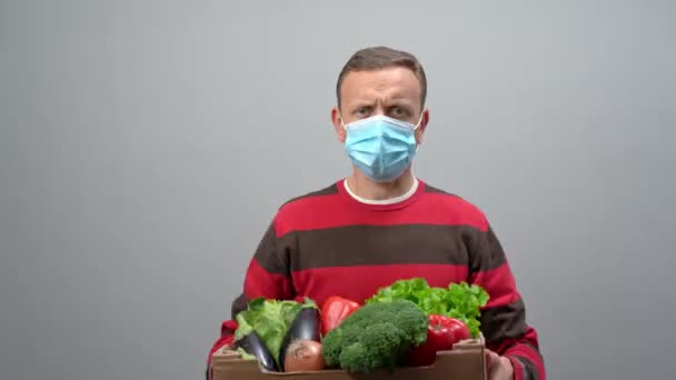 A male volunteer delivers food and vegetables to people in quarantine. Home insulation concept. Food delivery for people. Pandemic COVID-19 concept — Stock Video