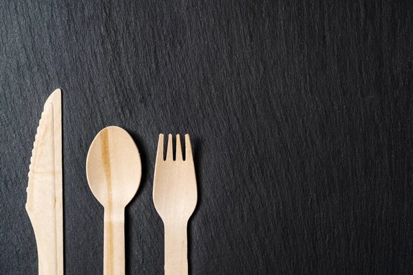 Jednorázové biologicky rozložitelné stolní nádobí z dřevěné lžíce, nože a vidličky na mramorové textuře. Detailní záběr. — Stock fotografie