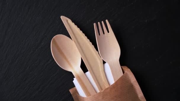 Wegwerp biologisch afbreekbaar servies gemaakt van houten lepel, mes en vork op marmeren textuur. Close-up. — Stockvideo