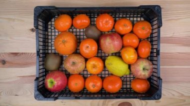 Bir adam, salgın sırasında market alışverişi yapmak için egzotik meyveleri bir kutuya koyar. Fakirlere yardım etmek. Düz yatıyordu.