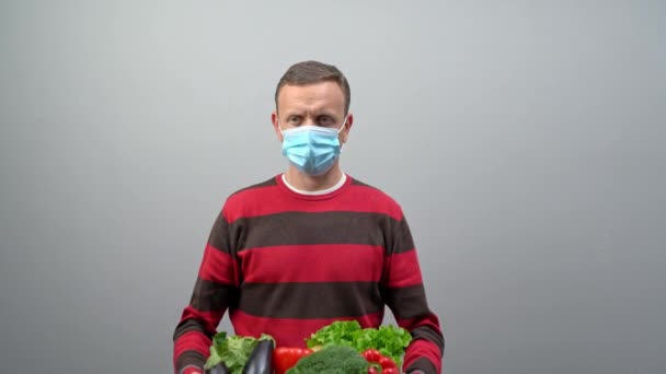 Um voluntário masculino entrega comida e vegetais a pessoas em quarentena. Conceito de isolamento doméstico. Entrega de comida para as pessoas. Conceito de pandemia COVID-19 — Vídeo de Stock