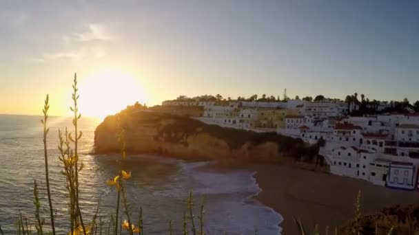 Álmodozó naplemente a sziklás partvonalakon Carvoeiro, Portugália. Sok lakással a távolban.. — Stock videók