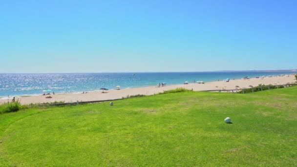 ポルトガルのヴァーレ・ド・ローボにある美しいビーチと輝く海の水の近くの草原フィールド. — ストック動画