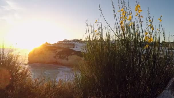 Pôr-do-sol sonhador na costa de um penhasco em Carvoeiro, Portugal. Com muita habitação à distância. — Vídeo de Stock