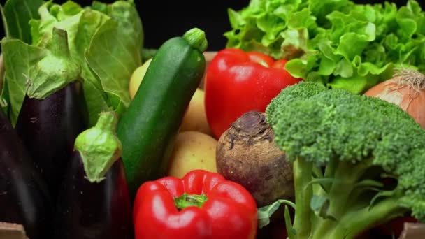 A box full of fresh vegetables on a dark background, wooden vintage table. In zoom motion. — Stock Video