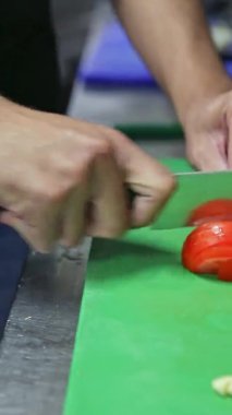 Ekolojik taze sebzeler aşçı tarafından yemek pişirmek için kesilir. Dikey video.