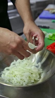 Şef taze sebzeleri mancınığa koyar. Dikey video. Yakın plan..