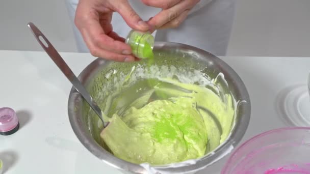 Close-up van bakker hand mengen gekleurd beslag met een siliconen spatel om macarons te bereiden. — Stockvideo