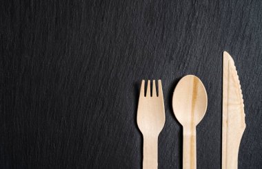 Tahta kaşık, çatal ve mermer dokudan yapılmış tek kullanımlık yemek takımı. Yakın plan..