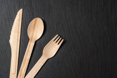 Tahta kaşık, çatal ve mermer dokudan yapılmış tek kullanımlık yemek takımı. Yakın plan..