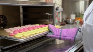 Fırıncı kadın fırından renkli bir tepsi makaron alıyor..