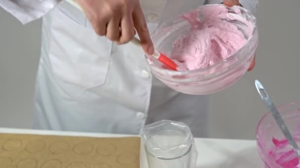 Koki menggunakan spatula untuk mengambil beberapa adonan makaron dari mangkuk untuk mengisi kantong kue. — Stok Video