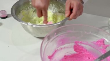 Fırıncı elinin kapağını kapat. Makaronları hazırlamak için renkli hamurla silikon spatulasını karıştır..