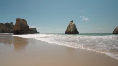 İlerliyor, dengeli, dalgalarla denizde, Prainha sahillerinde, yazın Avrupalı turistler için. Portekiz Portimao