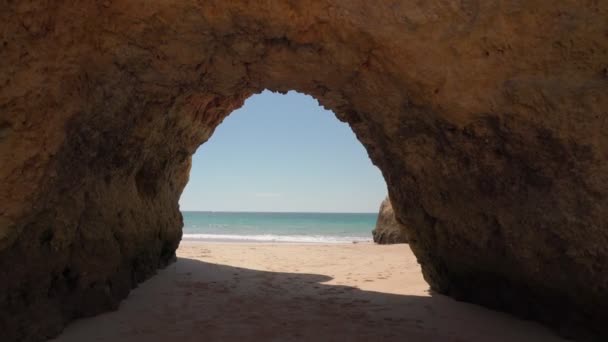 Avançando, estabilizado, saída da caverna para o mar com ondas, praia para turistas, no verão. — Vídeo de Stock