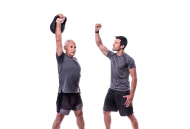 Spor hocasıyla egzersiz yapan yaşlı bir erkek müşteri, dambılı kaldırıyor. İzole edilmiş beyaz bir arkaplanda.