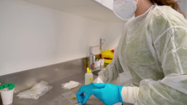 Microbiologo medico donna raccoglie campioni nasali per coronavirus da pazienti. Confezioni per analisi successive. — Video Stock