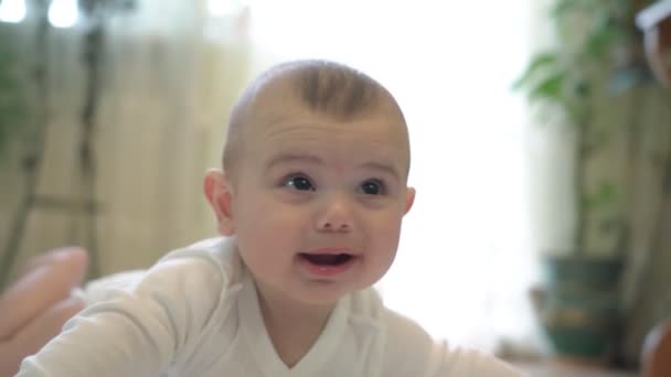 Un neonato giace soddisfatto e felice giocando, con emozioni positive. Sdraiato sulla mia pancia, con vista sulla camera da letto. — Video Stock