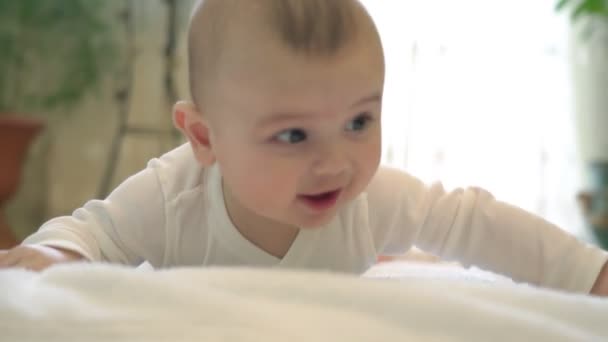 Een pasgeboren baby ligt tevreden en gelukkig te spelen, met positieve emoties. Liggend op mijn buik, met uitzicht op de slaapkamer. — Stockvideo