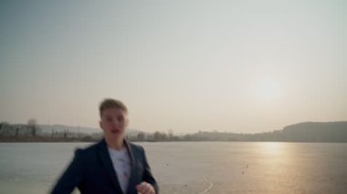Avrupalı bir adam, kırmızı ceketli, bir rap şarkısı söylüyor. Denizde, sahnenin ortasında..