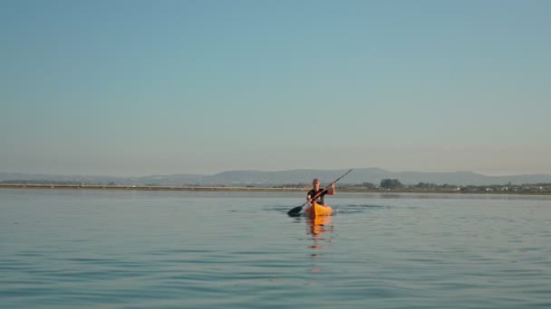 A sports man on a kayak conducts a training session on the lake, ocean. Preparing for the competition, paddling alone. March 16, 2021 Portugal Faro. — Αρχείο Βίντεο